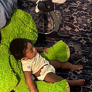 Mavrik joined the competition — help win amazing prizes! baby, child, diaper, plush_chair, green, carpet, furniture, indoor, person, onesie, infant, comfort, seated, cute, legs, soft, floor, young_child, relaxing, home