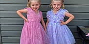 Avalinaandandilyn is registered to the contest to win money with this photo: child, girl, dress, pink, purple, bow, shoes, socks, smile, posing, outdoor, wooden_deck, wall, happy, fashion, tulle, ribbon, pearls, twins, cute