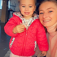 Kira a rejoint le concours — aidez-le/la à gagner de superbes lots ! child, toddler, woman, smiling, indoor, red_jacket, pacifier, pink_pants, heart_pattern, person, face, portrait, floor, wooden_ceiling, natural_light, cozy, happy, casual_clothing, family, home