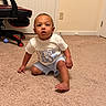 baby, birthday_boy, child, toddler, crawling, carpet, indoor, gaming_chair, blue_ball, white_ball, shorts, tshirt, person, floor, room, door, wall_outlet, curious, barefoot, home