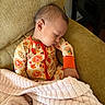 baby, sleeping, pajamas, blanket, armchair, cozy, indoors, child, comfort, cute, soft, relaxing, peaceful, autumn, patterned_clothing, person, furniture, head, hand, warm