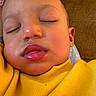 baby, sleeping, face, yellow_sweater, close_up, child, rosy_cheeks, peaceful, indoors, head, skin, person, portrait, resting, young_child, cozy, warm, soft_light, toddler, comfort