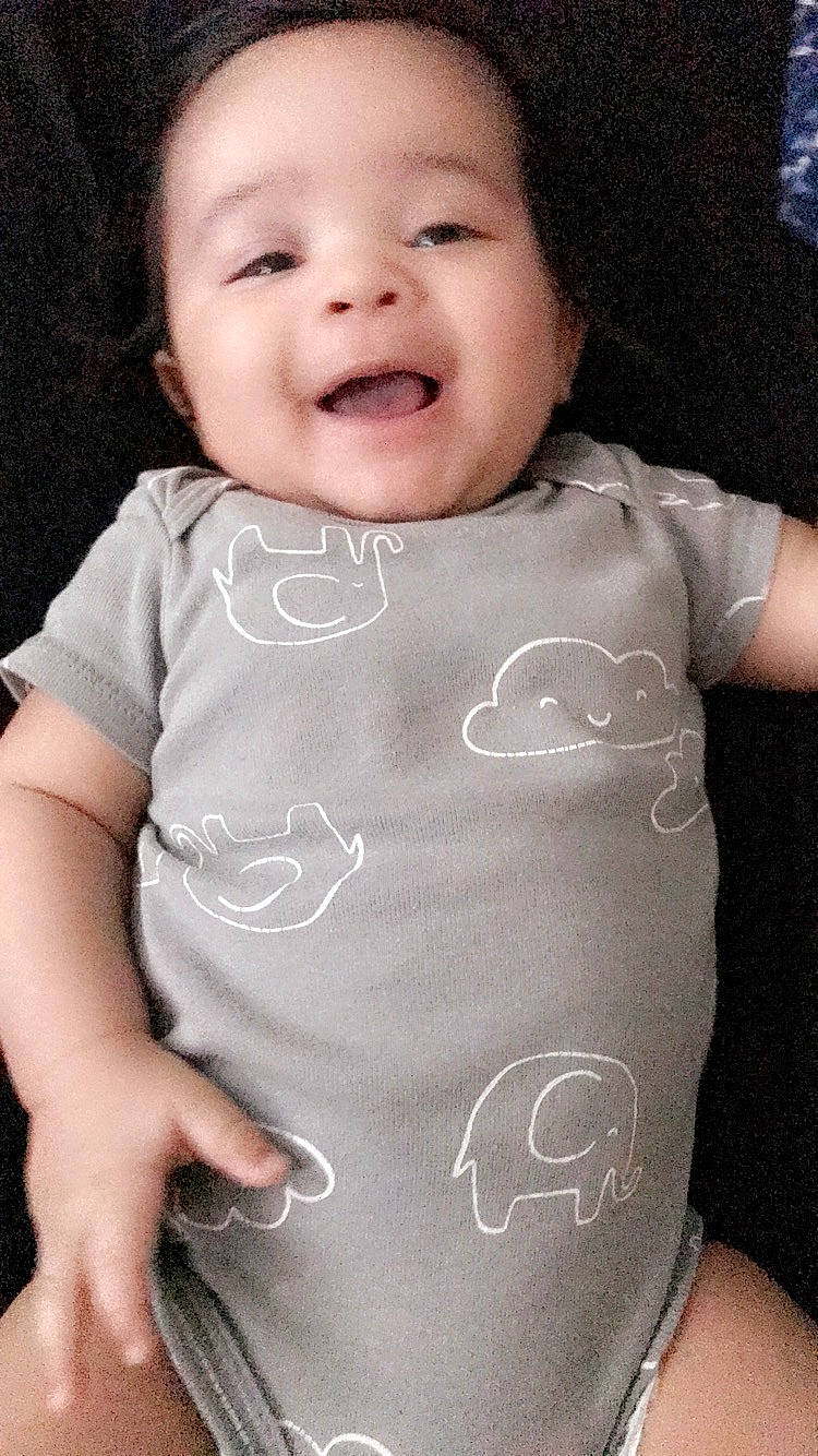 Tristian is registered to the contest to win money with this photo: arm, black_hair, cheek, child, face, facial_expression, finger, girl, hand, head, human, infant, joint, lip, mouth, nose, person, product, skin, smile