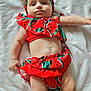 baby, blanket, child, chubby, closeup, cute, expression, fashion, headband, indoors, infant, lying_down, one_person, playful, red_clothing, skin, soft_texture, summer_outfit, toddler, watermelon