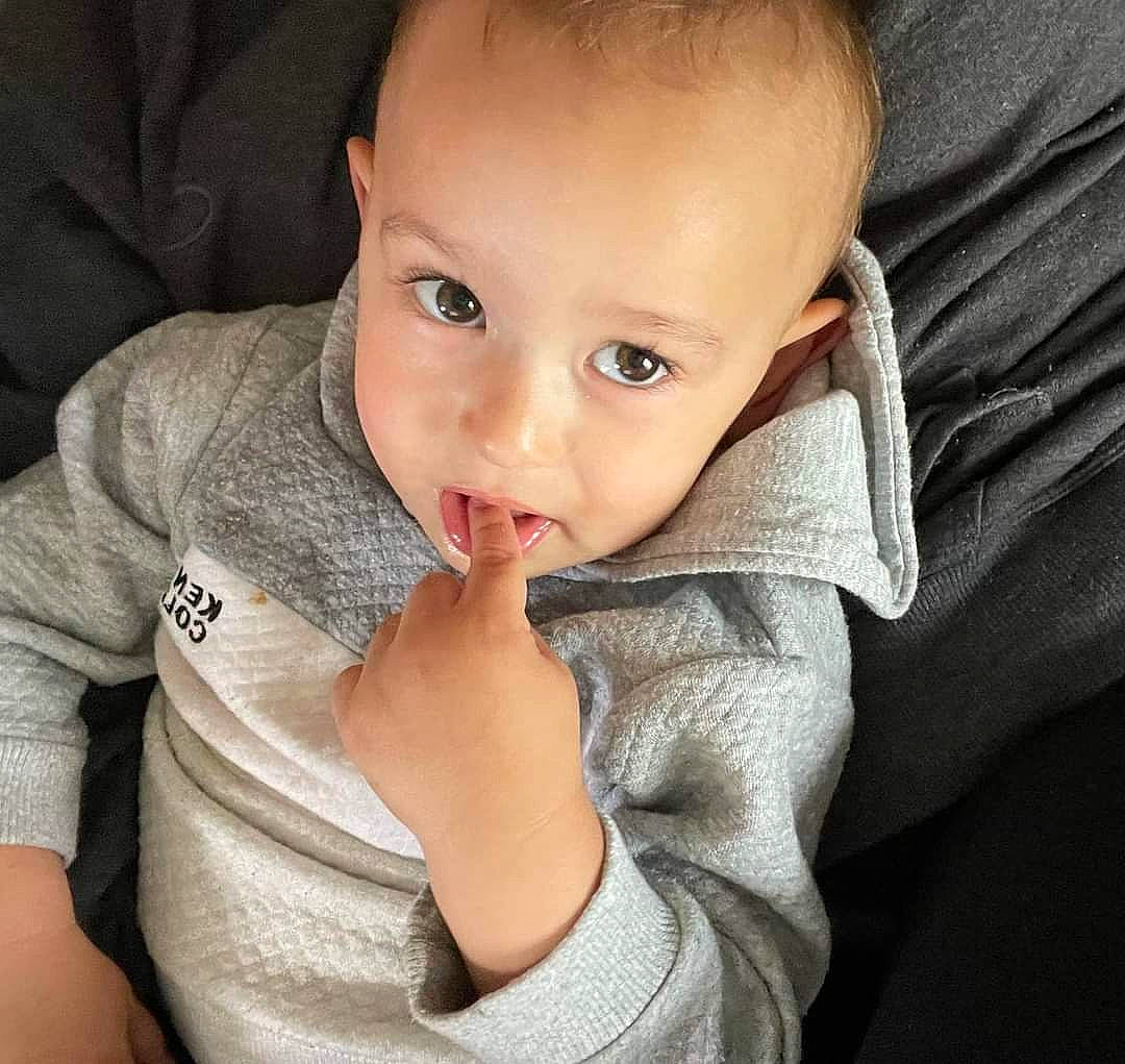 Xzavier is registered to the contest to win money with this photo: arm, baby, baby_toddler_clothing, cheek, collar, comfort, ear, eyelash, finger, gesture, grey, hand, happy, iris, lip, nose, person, skin, sleeve, thumb
