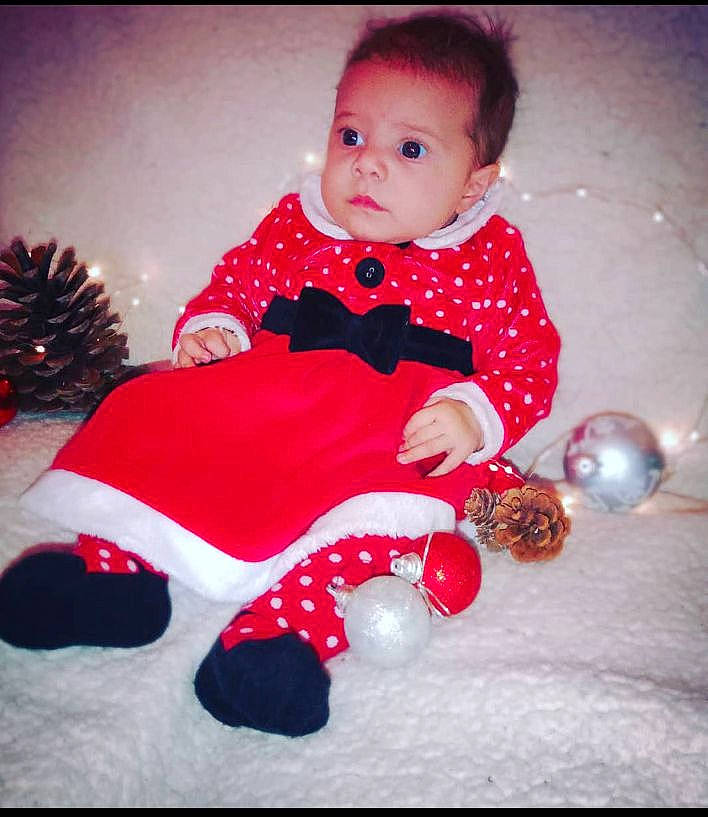 Laïa a rejoint le concours — aidez-le/la à gagner de superbes lots ! baby, baby_toddler_clothing, carmine, child, christmas_ornament, dress, event, face, flash_photography, happy, head, holiday, human_body, magenta, pattern, person, pink, sitting, sleeve, textile