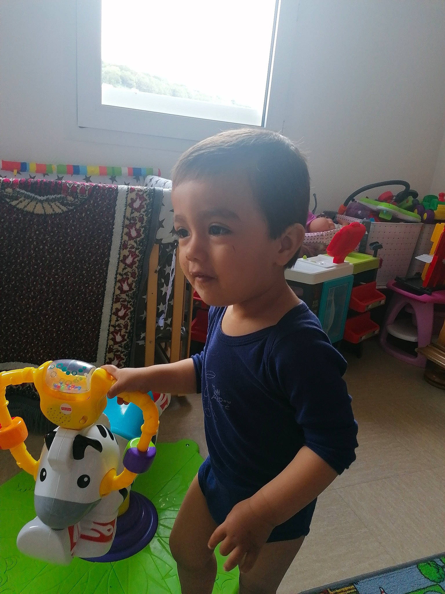 Alvin participe au concours pour gagner de l'argent avec cette photo : baby, baby_toys, box, chair, child, desk, flooring, fun, happy, person, play, room, sitting, smile, snapshot, t_shirt, television, toddler, toy, toy_vehicle