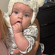 Clarice is registered to the contest to win money with this photo: baby, child, infant, blue_eyes, hand, hat, bear_hat, cute, person, clothing, sucking_fingers, portrait, indoor, adult_hand, holding, face, expression, soft_texture, warm, young