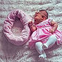 baby, infant, pink_dress, white_tights, headband, smiling, fluffy_blanket, soft_texture, lying_down, cute, child, newborn, pet_bed, pink, white, cozy, indoors, resting, happy, adorable