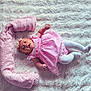 baby, infant, pink_dress, headband, white_tights, lying_down, blanket, plush, soft_texture, cute, child, smiling, indoors, cozy, portrait, adorable, resting, happy, baby_clothing, toddler
