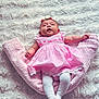 baby, infant, pink_dress, floral_headband, white_tights, blanket, soft_texture, lying_down, cute, child, portrait, cozy, indoors, infant_clothing, baby_fashion, adorable, sleeping_area, resting, small_child, headwear