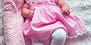Ciarah Aaliyah joined the competition — help win amazing prizes! baby, infant, smiling, pink_dress, white_tights, headband, flower_headband, blanket, soft_texture, lying_down, happy, cute, child, portrait, indoors, fluffy_surface, rolled_blanket, small_hands, small_feet, cheerful