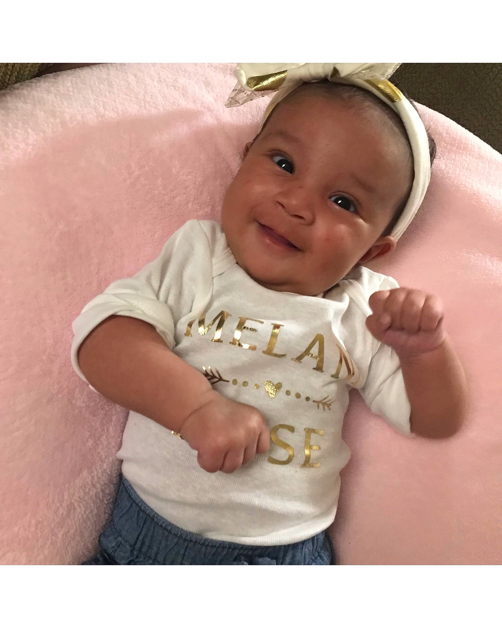 Melani is registered to the contest to win money with this photo: arm, baby, baby_products, baby_toddler_clothing, beige, cheek, child, ear, neck, person, pink, product, skin, sleeve, smile, t_shirt, toddler