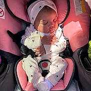 Dazaiah is registered to the contest to win money with this photo: baby, car_seat, child, clothing, cute, footwear, hands, headband, indoor, infant, onesie, peaceful, pink, portrait, resting, seatbelt, shadow, sleeping, soft, sunlight