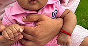 Estefany is registered to the contest to win money with this photo: baby, infant, child, pink_clothing, headband, hand, adult_hand, outdoor, grass, blanket, skin, portrait, closeup, expression, cute, bracelet, person, nature, baby_girl, summer