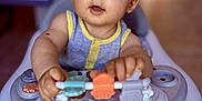 Linzo participe au concours pour gagner de l'argent avec cette photo : baby, blue_eyes, blurred_background, child, closeup, clothing, curious, cute, exploring, face, hands, indoor, infant, light_hair, person, playtime, seat, toy, walker, young