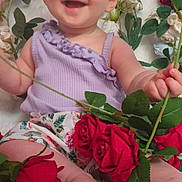 Ilona a rejoint le concours — aidez-le/la à gagner de superbes lots ! baby, child, smiling, flowers, roses, purple_top, floral_shorts, green_leaves, happy, sitting, cute, portrait, nature, plant, petals, skin, foot, hand, indoors, colorful