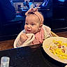 Anova is registered to the contest to win money with this photo: baby, bib, child, clothing, face, food, hand, happy, headband, indoor, infant, meal, people, plate, restaurant, sitting, smile, table, towel, woman