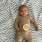 Aria joined the competition — help win amazing prizes! age_marker, baby, baby_photography, blanket, child, clothing, cute, expression, face, foot, hand, indoor, infant, lying_down, onesie, pattern, portrait, soft, texture, wooden_sign