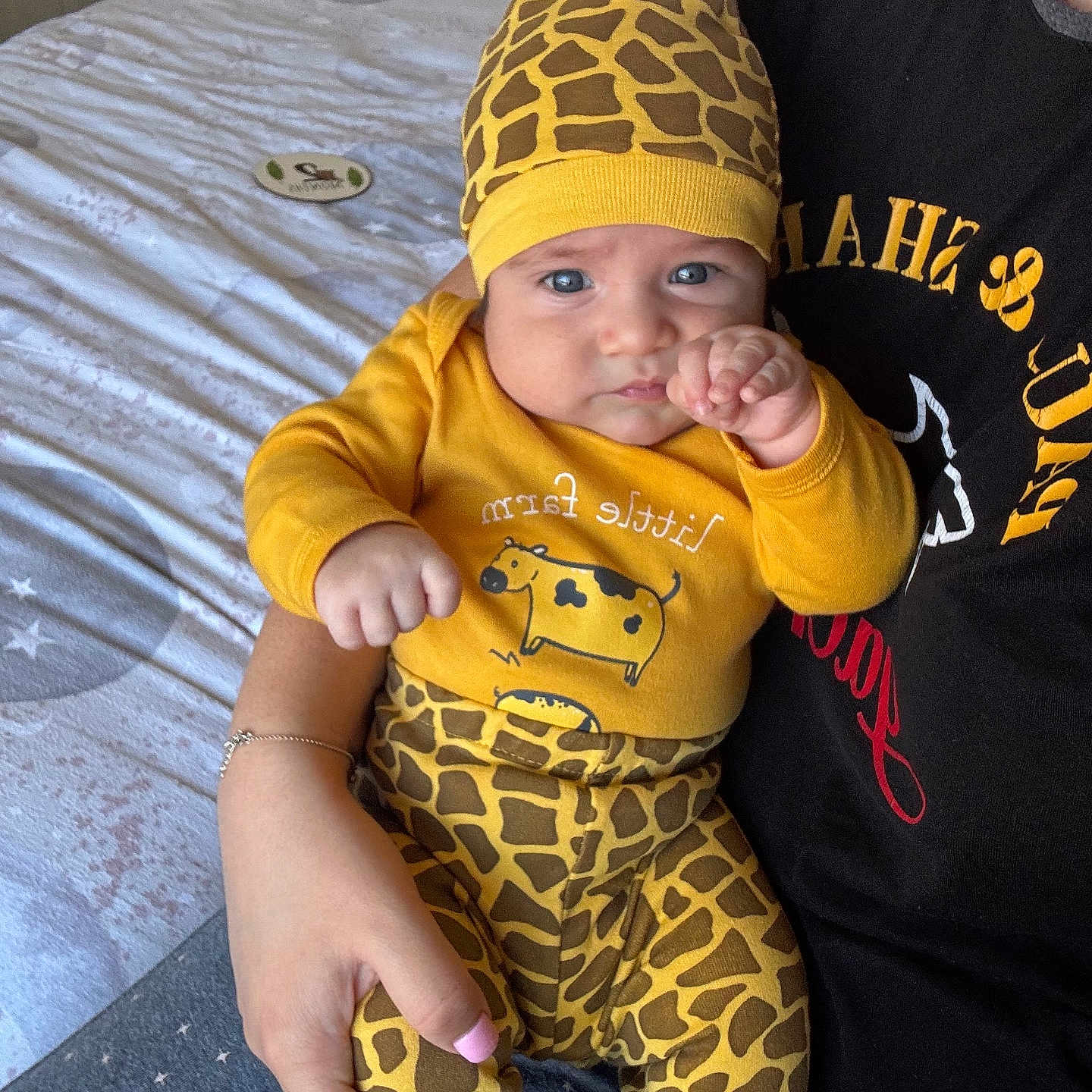 Christian is registered to the contest to win money with this photo: accessories, baby, bed, bedroom, cap, clothing, face, furniture, hat, head, indoors, jewelry, necklace, newborn, pants, person, photography, portrait, room, t_shirt