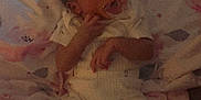 Treazure is registered to the contest to win money with this photo: baby, pacifier, blanket, pajamas, infant, lying_down, soft_lighting, indoor, floral_pattern, child, cute, small_hands, sleepwear, comfort, resting, newborn, face, person, bed, relaxed