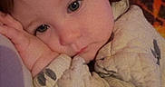 Kinsley joined the competition — help win amazing prizes! baby, child, face, portrait, clothing, patterned_clothing, skin, hand, arm, expression, indoor, closeup, person, young_child, resting, comfort, warmth, colorful_background, soft_light, cute
