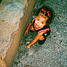 Cimani joined the competition — help win amazing prizes! child, girl, red_bows, hair_accessory, black_clothing, sneakers, crouching, concrete, sidewalk, wall, outdoor, curious, playful, looking_up, daylight, casual, street, person, young, innocence