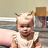 baby, child, infant, portrait, sitting, couch, indoors, face, eyes, hair, pigtails, dress, clothing, pink, smiling, serious_expression, furniture, living_room, photography, person
