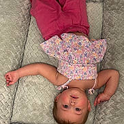 Kennedi joined the competition — help win amazing prizes! baby, child, infant, portrait, lying_down, upside_down, smiling, floral_clothing, pink_clothing, blanket, soft_texture, indoor, closeup, face, eyes, hair, arms, legs, playful, cozy