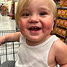 Xander joined the competition — help win amazing prizes! baby, child, toddler, smiling, happy, portrait, close_up, face, blond_hair, blue_eyes, shopping_cart, supermarket, grocery_store, store_aisle, sitting, white_shirt, sleeveless, indoors, shelves, food_products