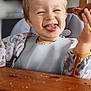 toddler, child, smiling, happy, face, messy, food, bib, highchair, table, wooden_table, indoor, clothing, dinosaur_print, mess, crumbs, cute, young_child, portrait, laughter