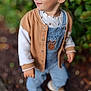 toddler, child, smiling, outdoor, greenery, jacket, overalls, shoes, curly_hair, cute, portrait, happy, nature, young_child, casual_clothing, standing, daylight, fashion, playful, baby