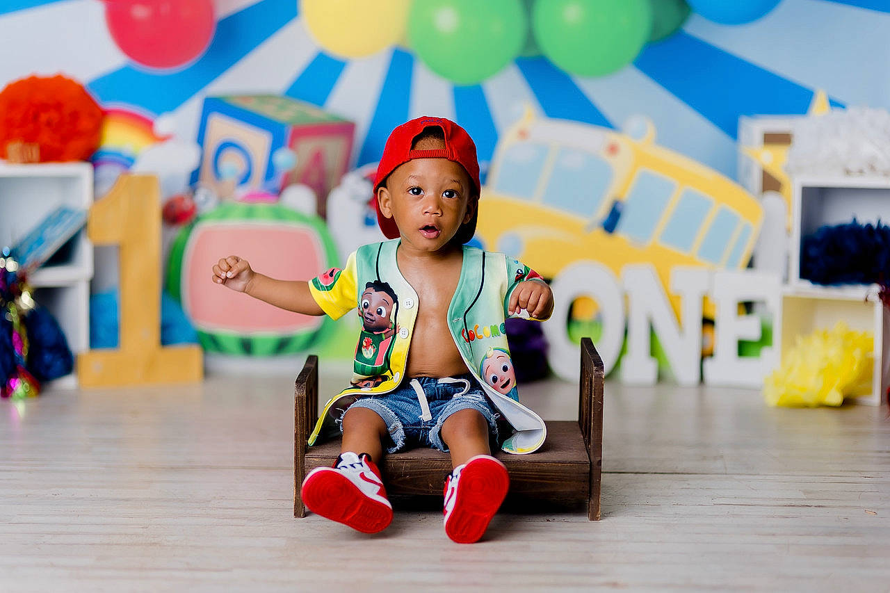 Keegan is registered to the contest to win money with this photo: balloon, child, event, flooring, fun, happy, headwear, leisure, orange, party, party_supply, person, photograph, play, recreation, room, summer, surprise, toddler, toy