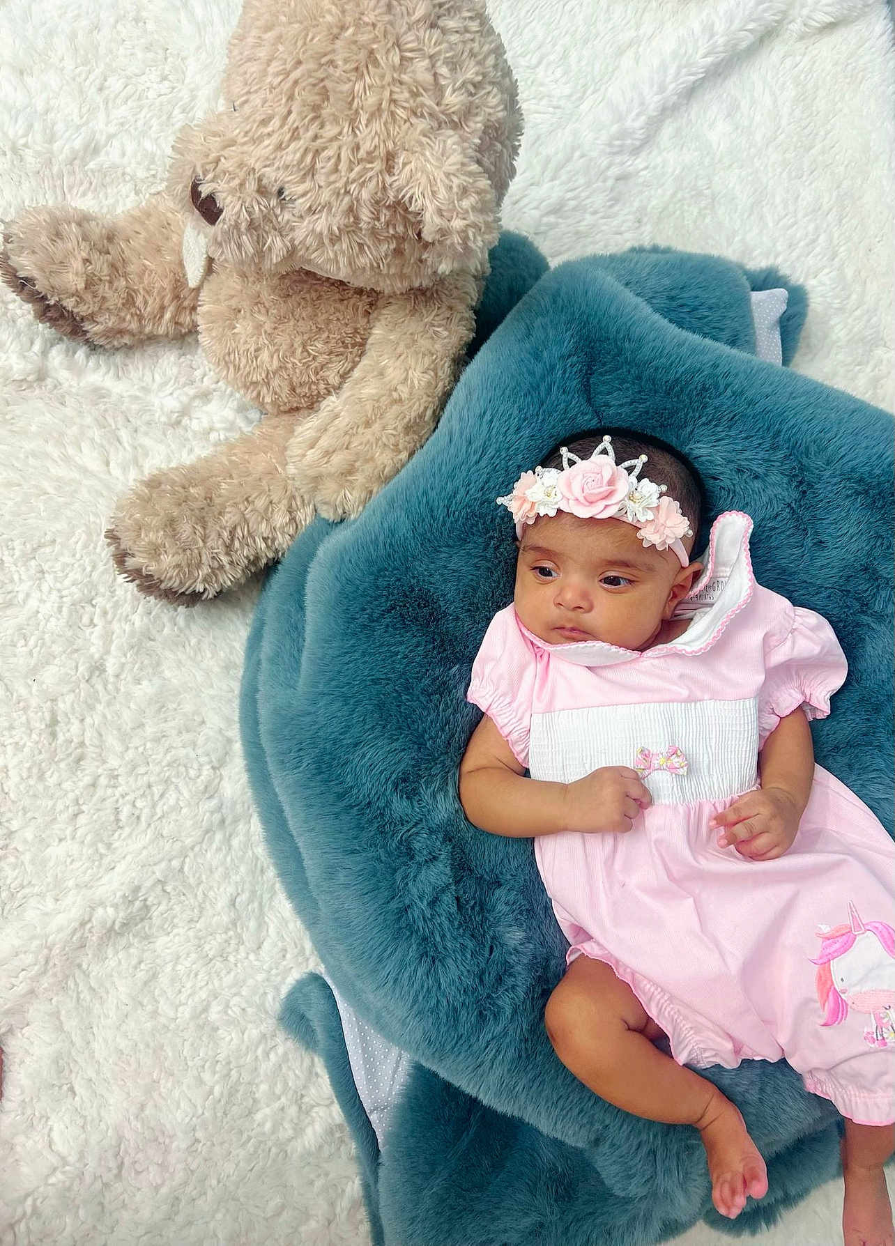Anaya joined the competition — help win amazing prizes! baby, infant, pink_outfit, headband, flower_crown, unicorn, plush_toy, teddy_bear, blue_blanket, white_rug, soft_texture, cute, child, portrait, lying_down, indoor, adorable, cozy, small_hands, small_feet