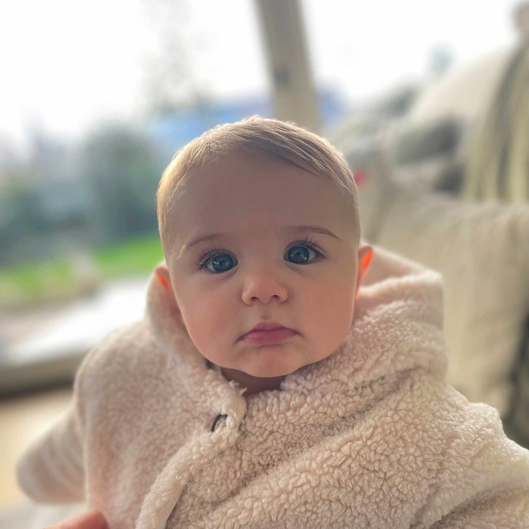 Hannah a rejoint le concours — aidez-le/la à gagner de superbes lots ! baby, blue_eyes, child, closeup, cute, expression, eyelashes, face, fluffy_jacket, hand, hooded_clothing, indoor, mouth, nose, person, portrait, skin, soft_focus, warm_clothing, young_child