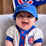 Leeland joined the competition — help win amazing prizes! baby, child, smiling, baseball_cap, sportswear, cubs_logo, blue, white, pinstripes, infant, portrait, happy, team_spirit, sitting, clothing, hat, background, flag, cute, person
