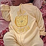 Amari is registered to the contest to win money with this photo: baby, blanket, child, cozy, cute, face, foot, hand, head, indoors, infant, lying_down, newborn, onesie, patterned_blanket, person, portrait, sleepwear, soft_lighting, yellow_clothing