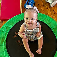 Magnolia joined the competition — help win amazing prizes! toddler, child, smiling, sitting, indoor, trampoline, toy, dress, bow, floor, wooden_floor, play, happy, face, person, cute, colorful, baby_toy, footwear_free, hair_accessory