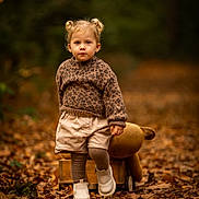 Capucine participe au concours pour gagner de l'argent avec cette photo : child, toddler, autumn, leaves, forest, portrait, sweater, shorts, boots, plush_toy, wooden_wagon, pigtails, blonde_hair, blue_eyes, walking, bokeh, fall_colors, outdoor, candid, cozy