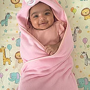 Nia is registered to the contest to win money with this photo: baby, pink_blanket, bunny_ears, smiling, infant, cute, animal_print, lion, giraffe, elephant, zebra, child, soft_texture, wrapped, lying_down, happy, indoors, pastel_colors, toddler, blanket