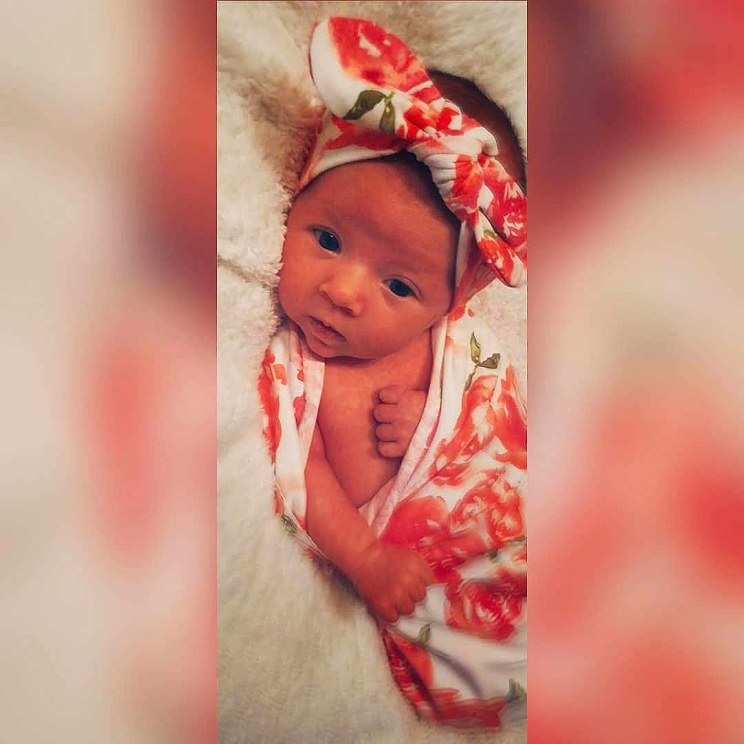 Ember is registered to the contest to win money with this photo: baby, cheek, child, ear, eye, face, flesh, hair_accessory, head, lip, person, photography, pink, plant, red, skin, smile, toddler
