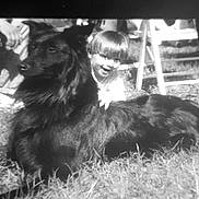 Gamin participe au concours pour gagner de l'argent avec cette photo : black_dog, child, grass, outdoor, vintage_photo, black_and_white, smiling, pet, dog, happy, playing, childhood, animal, grass_field, sunlight, chair, people, leisure, friendship, portrait