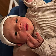 Harry participe au concours pour gagner de l'argent avec cette photo : baby, newborn, infant, hat, sweater, clothing, face, hand, fingers, expression, portrait, indoor, person, skin, headwear, cute, young_child, lying_down, closeup, baby_gesture