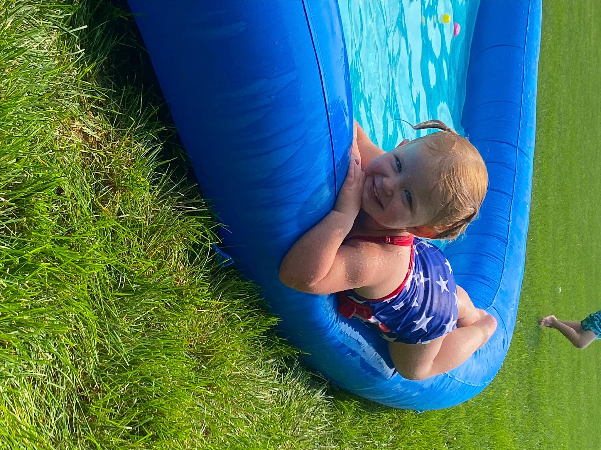 Payton Lee is registered to the contest to win money with this photo: blue, child, elbow, electric_blue, fun, grass, happy, human_body, human_leg, joint, joy, knee, lawn, leg, leisure, people_in_nature, person, recreation, sitting, t_shirt