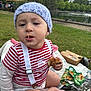 toddler, child, baby, hat, knitted_hat, striped_shirt, suspenders, food, bread, picnic, blanket, grass, park, outdoor, nature, pond, trees, daytime, cute, sitting