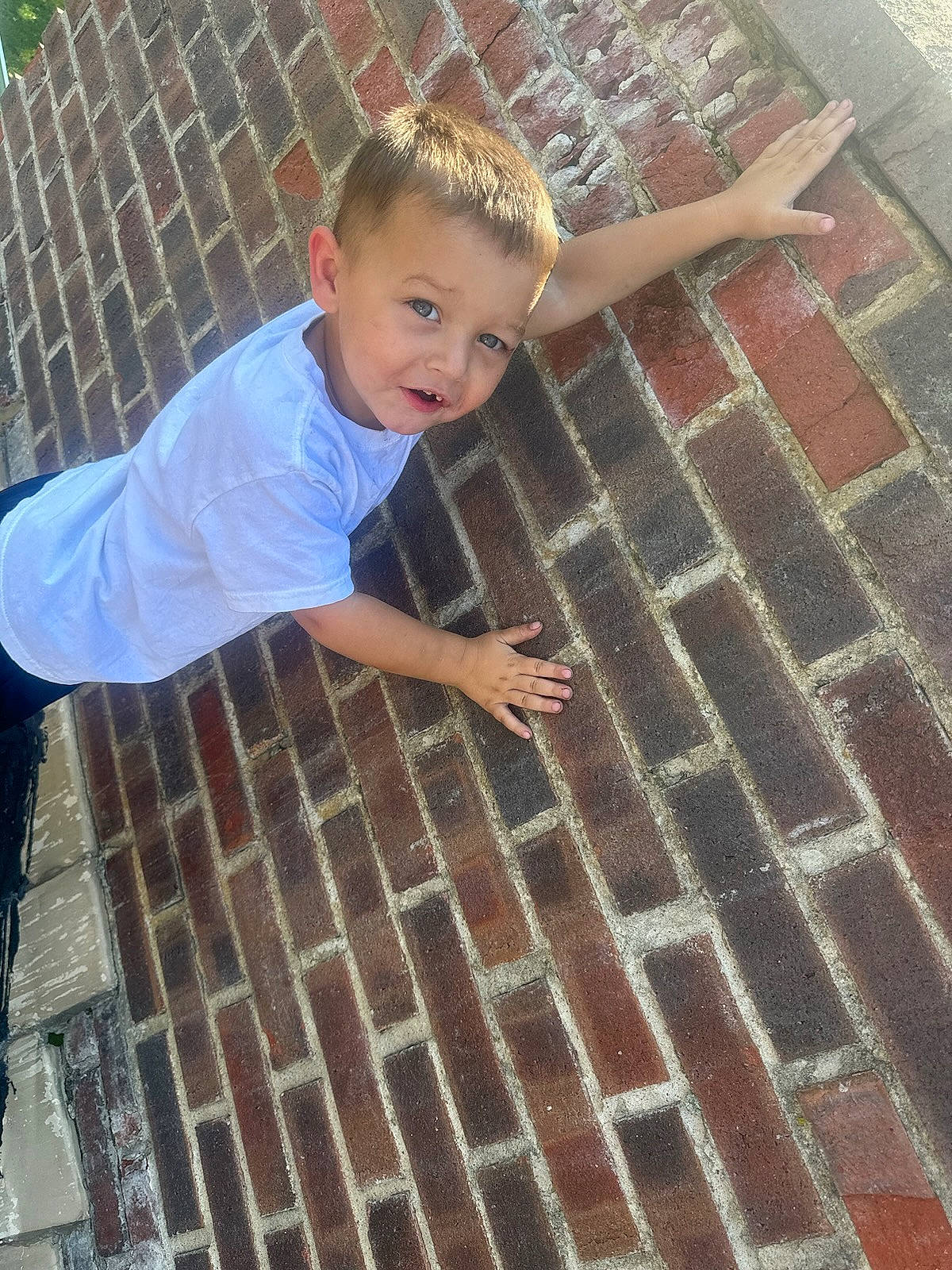 Braxten joined the competition — help win amazing prizes! brick, brickwork, child, cobblestone, composite_material, flagstone, floor, flooring, fun, hardwood, pattern, person, road_surface, shadow, sidewalk, sitting, t_shirt, toddler, vertebrate, water