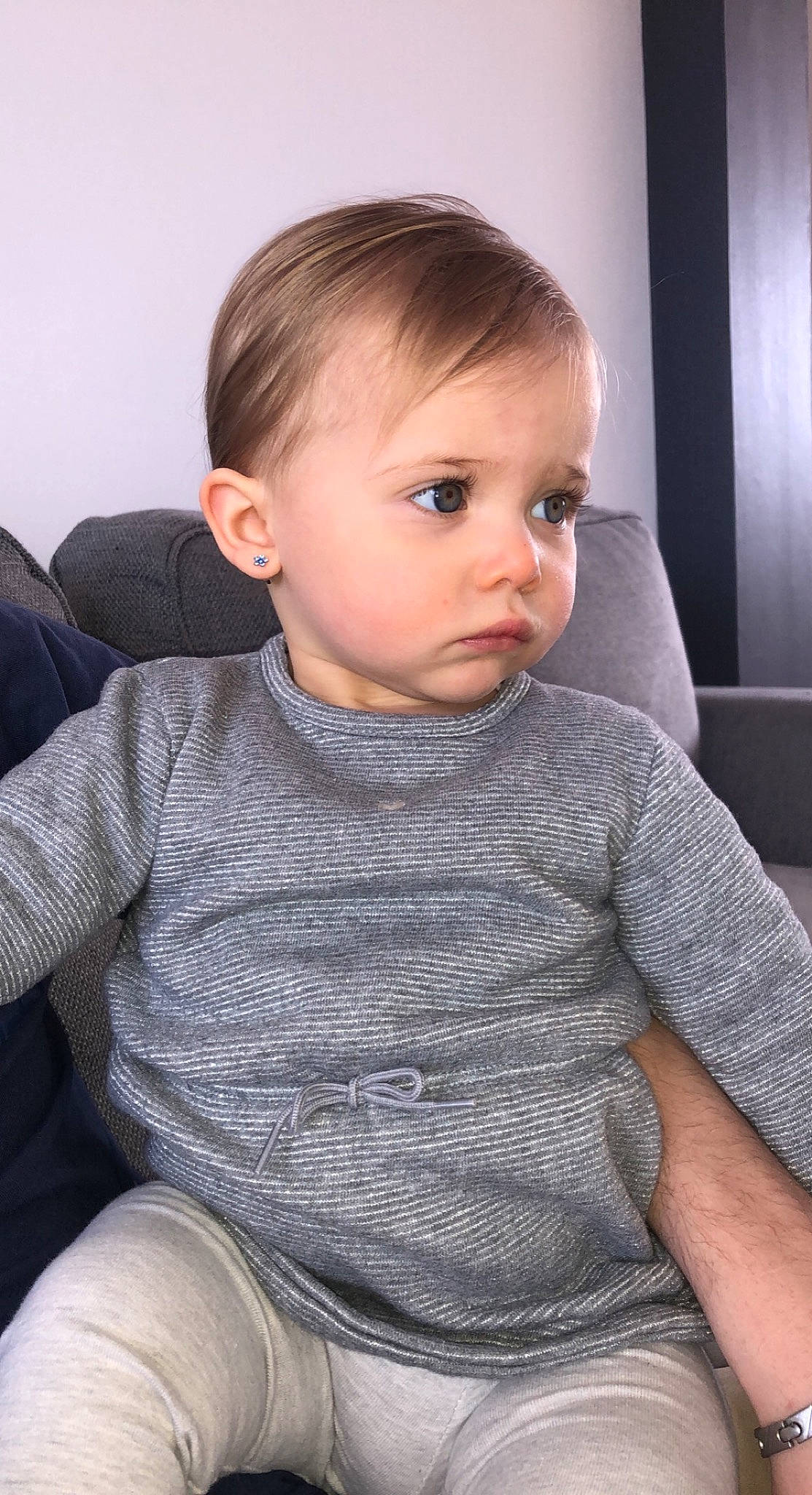 Leya participe au concours pour gagner de l'argent avec cette photo : arm, baby, baby_toddler_clothing, cheek, comfort, eye, eyelash, grey, hair, head, human_body, iris, lip, neck, nose, person, skin, sleeve, t_shirt, toddler