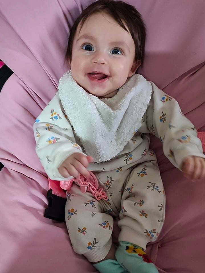 Léanna a rejoint le concours — aidez-le/la à gagner de superbes lots ! baby, baby_toddler_clothing, cheek, child, collar, comfort, eye, finger, gesture, happy, head, linens, pattern, person, pink, sitting, skin, sleeve, smile, textile