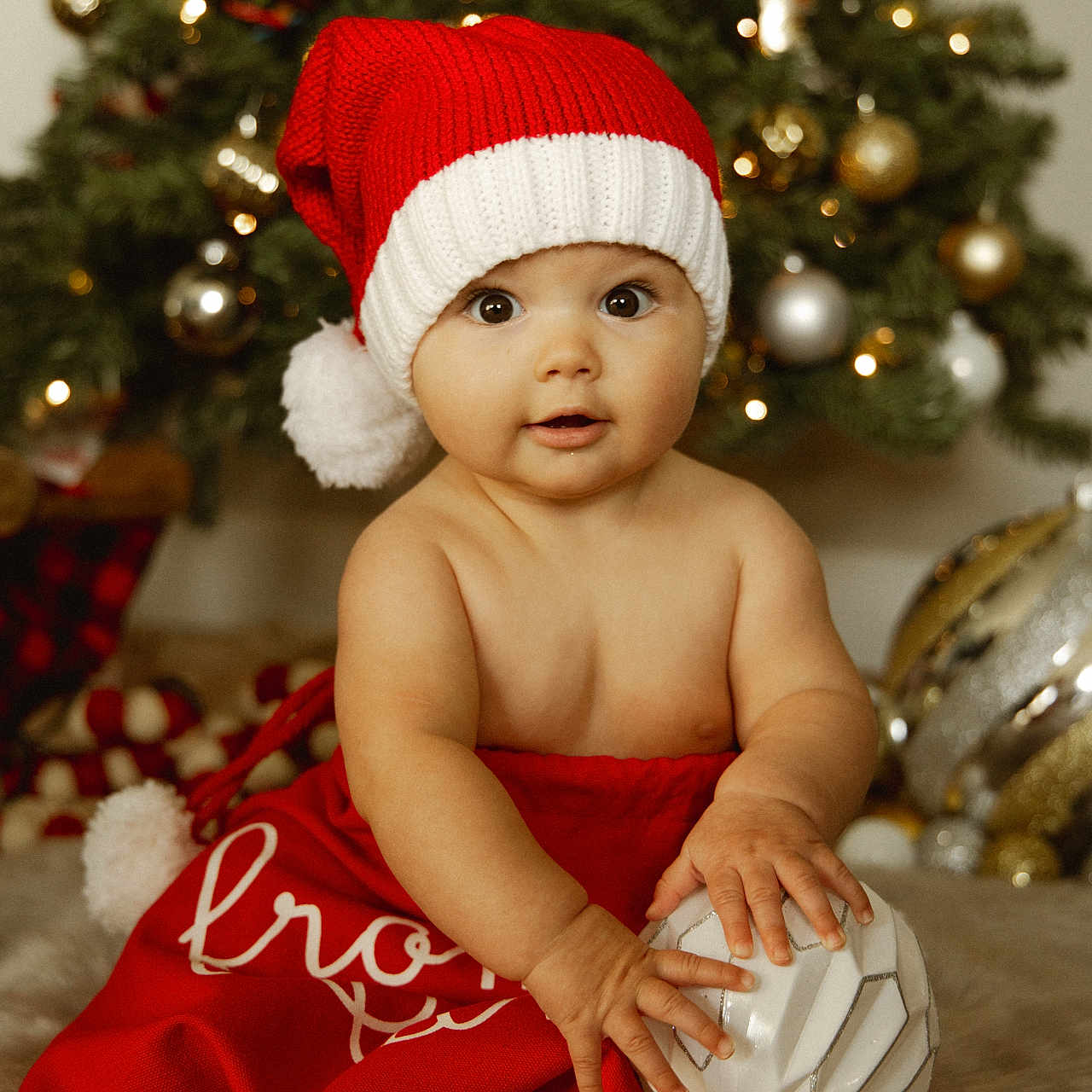 Oakley is registered to the contest to win money with this photo: baby, ball, beanie, bodypart, bonnet, cap, christmas, christmasdecorations, clothing, face, festival, finger, football, hand, hat, head, person, soccer, soccerball, sport