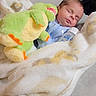 newborn, baby, sleeping, blanket, bottle, plush_toy, dinosaur, cozy, bedtime, infant, soft, cute, indoors, comfort, child, rest, peaceful, clothing, pillow, fabric